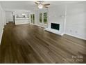 Open-concept living room with wood-look floors, fireplace, and breakfast bar into the kitchen at 424 Mallard Dr, Pineville, NC 28134