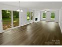 Spacious living room with wood-look flooring, brick fireplace, and sliding doors to the backyard at 424 Mallard Dr, Pineville, NC 28134