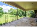 View from covered porch showing mature backyard trees and greenery at 5635 Highway 55 E Hwy, Clover, SC 29710