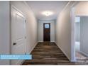 Inviting hallway featuring beautiful hardwood floors and a view of the front door at 608 Banter Ln # 31, Cramerton, NC 28032