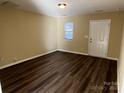 Bright living room showcasing sleek dark wood floors and a door for convenient access at 6130 Sid Crane Dr, Charlotte, NC 28216