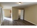Open living area with dark wood floors, light walls, and kitchen access at 6130 Sid Crane Dr, Charlotte, NC 28216