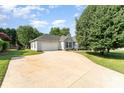Inviting exterior showcasing a well-maintained lawn, a mature tree, and a long driveway leading to an attached garage at 614 W Peeler St, Salisbury, NC 28146