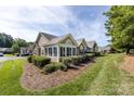 A beautifully landscaped home exterior with stone accents, a pristine lawn, and well-maintained shrubs at 6811 Ledgestone Pl, Charlotte, NC 28227