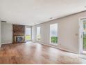 Bright living room with a brick fireplace and hardwood floors at 7217 Rena Mae Ln, Charlotte, NC 28227