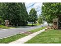 Scenic neighborhood street view with Auburn Place entrance monuments and lush greenery at 8409 Darcy Hopkins Dr, Charlotte, NC 28277