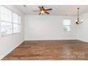 Spacious living room with hardwood floors, natural light from large windows, and a contemporary ceiling fan at 1007 Green Terra Rd, Indian Trail, NC 28079