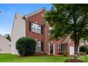 Charming two-story brick home with a well-manicured lawn and attached two-car garage at 11305 Erwin Ridge Ave, Charlotte, NC 28213