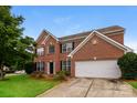 Charming two-story brick home with a well-manicured lawn and attached two-car garage at 11305 Erwin Ridge Ave, Charlotte, NC 28213