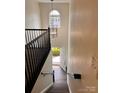 Bright entryway featuring dark hardwood floors, an elegant chandelier, and black banister at 115 Morrocroft Ln, Mooresville, NC 28117
