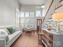 Bright living room featuring high ceilings, large windows, a comfortable seating area, and hardwood floors at 1169 Stuarts Landing Dr, Cramerton, NC 28032