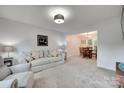 Bright living room open to dining area with neutral carpet at 12004 Woodholm Ct, Tega Cay, SC 29708