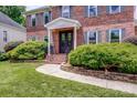 Charming brick home with covered entry, walkway, and professionally landscaped front yard at 12416 Stirling Trace Ct, Charlotte, NC 28277