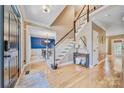 Bright foyer featuring hardwood floors, staircase, chandelier, and view into the dining room at 12434 Sylvan Oak Way, Charlotte, NC 28273