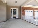 Covered front porch leading to a white framed front door at 14019 Cameryn Elise Dr, Cornelius, NC 28031