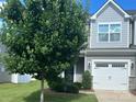 Charming two-story home featuring a well-manicured lawn, a white garage door, and gray siding at 15005 Savannah Hall Dr # 72, Charlotte, NC 28273
