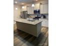 Bright kitchen with stainless steel appliances, white cabinets, a large island, and modern pendant lighting at 15005 Savannah Hall Dr # 72, Charlotte, NC 28273
