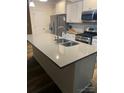 Modern kitchen with stainless steel appliances, white cabinets, a gray countertop, and a center island at 15005 Savannah Hall Dr # 72, Charlotte, NC 28273