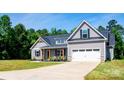 The property boasts charming curb appeal, featuring a well-manicured lawn and a classic garage at 205 Spring Creek Dr, Mount Holly, NC 28120