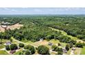 An aerial view of a sprawling lot surrounded by lush greenery, showcasing the neighborhood and stunning property at 237 Mariposa Rd, Stanley, NC 28164