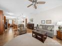 Open-concept living room flowing into the kitchen with hardwood floors and ceiling fan at 24604 Blue Heron Cir, Lancaster, SC 29720