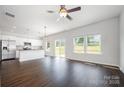 Bright, open-concept living space featuring dark floors, a ceiling fan, and a seamless flow to the modern kitchen at 3001 Sadler Woods Ln, Charlotte, NC 28214