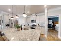 Modern kitchen featuring white cabinets, stainless steel appliances, granite countertops and hanging pendant lights at 320 Secretariat Dr, Iron Station, NC 28080
