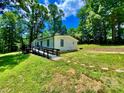 Ranch-style home with a ramp for accessibility and a lush lawn surrounded by mature trees on a sunny day at 325 Scaley Bark Dr, Salisbury, NC 28147