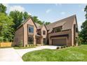 Elegant brick home with a lush green lawn and large driveway leading to an attached garage at 412 Jefferson Dr, Charlotte, NC 28270