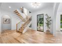 Bright foyer featuring hardwood floors, modern staircase, contemporary chandelier, and a view of the outdoors at 412 Jefferson Dr, Charlotte, NC 28270