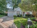 Inviting single-Gathering home featuring a landscaped front yard, driveway, attached garage, and charming curb appeal at 4801 Pennant Pl, Charlotte, NC 28212