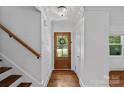 Inviting entryway featuring a wood door with glass, hardwood floors, and a stylish chandelier at 5611 Robinhood Rd, Charlotte, NC 28211