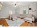 Bright living room features hardwood floors, a large sectional couch, and a ceiling fan at 626 Cabarrus W Ave, Concord, NC 28027