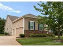 Side exterior featuring a three-car garage and brick accents, complemented by a well-maintained lawn at 6506 Jepson Ct # 349, Charlotte, NC 28214