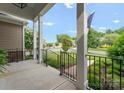 Covered front porch with black railing, offering a view of the landscaped yard and quiet neighborhood at 6506 Jepson Ct # 349, Charlotte, NC 28214