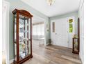 Inviting foyer featuring a display cabinet, wood flooring, and a white front door at 7029 Forest Hills Dr # 38, Denver, NC 28037