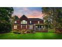 Expansive backyard with well-maintained lawn, patio seating, and screened porch at 8102 Bergen Ct, Waxhaw, NC 28173