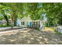 Cozy one-story house boasting a bright blue door and a cute, covered porch with stairs leading to the basement at 909 Gibbons St, Gastonia, NC 28052