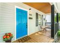 Close-up of the front porch featuring a blue door, seating, and seasonal decorations, creating a warm welcome at 909 Gibbons St, Gastonia, NC 28052