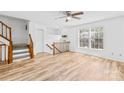 Inviting living room with open staircase, ceiling fan, and wood-look floors at 9639 Green Gable Ct, Charlotte, NC 28270