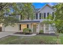 Charming two-story home with light siding, black shutters, green door, and well-maintained landscaping at 11407 Lenswood Ct, Charlotte, NC 28214