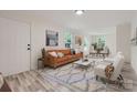 Bright, staged living room with modern furniture, light wood flooring, and ample natural light at 1224 E Woodlawn Rd, Charlotte, NC 28209