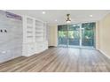 Light-filled living room showcasing balcony access, built-in shelves, and wood flooring at 1300 Queens Rd # 409, Charlotte, NC 28207