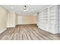 Open living space with hardwood floors, built-in shelving, and a ceiling fan at 1300 Queens Rd # 409, Charlotte, NC 28207