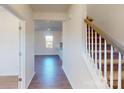 Inviting foyer with hardwood flooring, view to the living room, and staircase with carpeted treads at 1821 Augustine St, Monroe, NC 28112