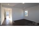 Spacious living room with dark hardwood flooring, bright natural light, and crisp white walls at 1821 Augustine St, Monroe, NC 28112