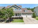 Inviting two-story home with a two-car garage, a welcoming front porch, and beautifully maintained landscaping at 2052 Masons Bend Dr, Fort Mill, SC 29708