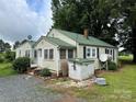 Exterior view of home with metal roof and grass yard at 30497 Orchard Ln, Albemarle, NC 28001