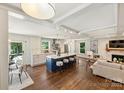 Open concept living space with a modern kitchen, large island with seating, hardwood floors, and a cozy fireplace, great for entertaining at 3165 Pendleton Ave, Charlotte, NC 28210