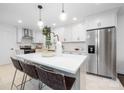 Modern kitchen with white cabinets, stainless steel appliances, and a large center island at 4017 Sulkirk Rd, Charlotte, NC 28210